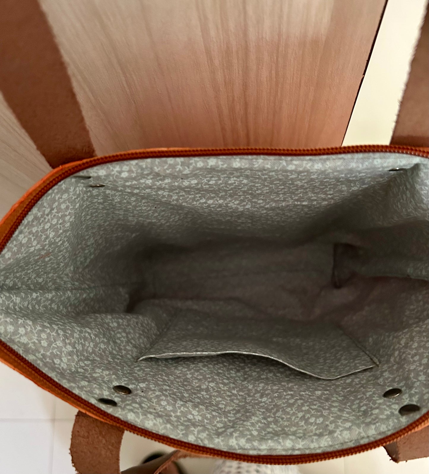 Top view of tote bag showing zipper closure And inside of the bag