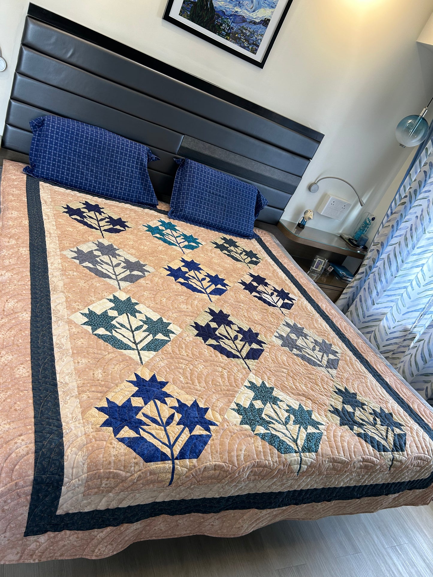 Distance view of blue and beige quilt on bed