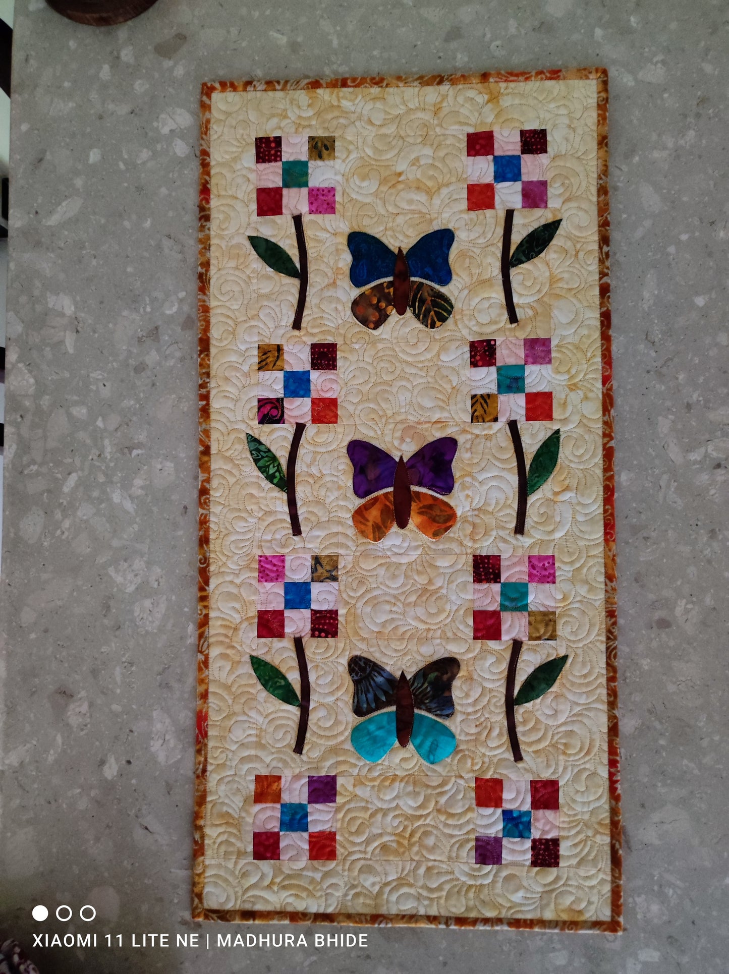 Quilted butterfly-themed runner with floral accents