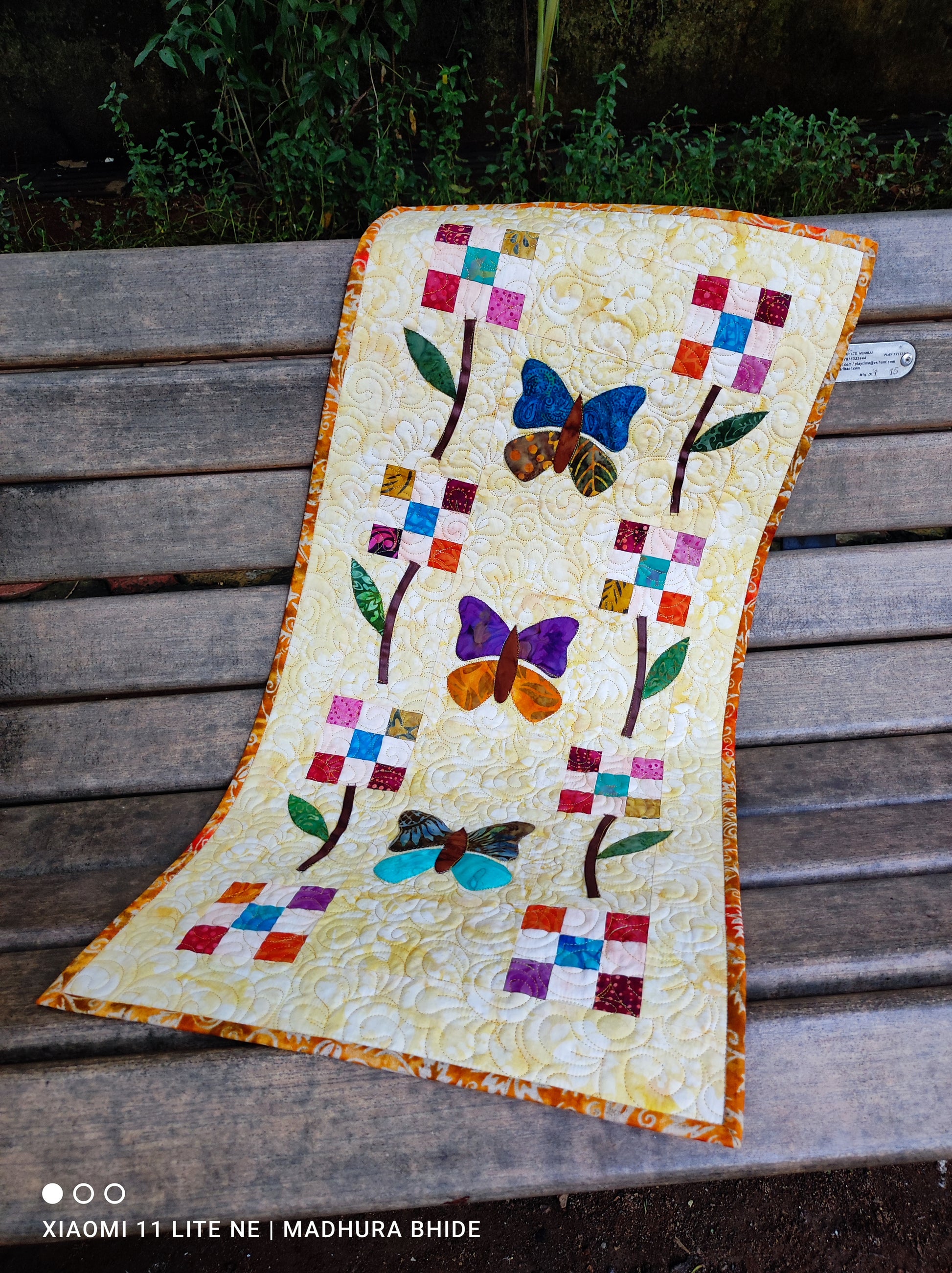 Bright patchwork table runner with handmade stitching
