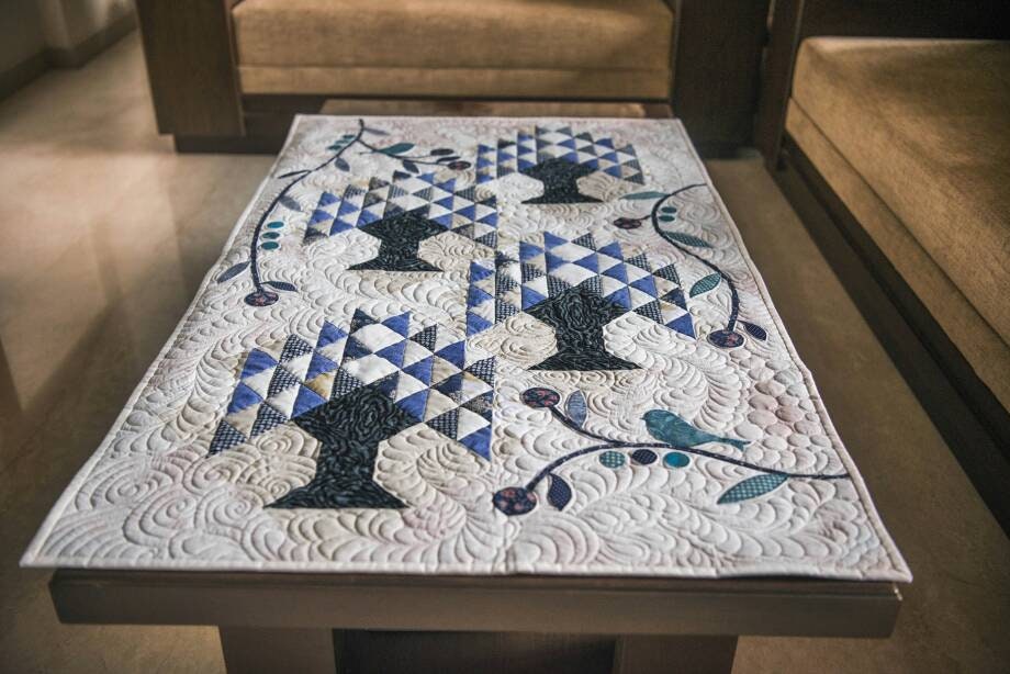 Front view of blue and cream quilt on table