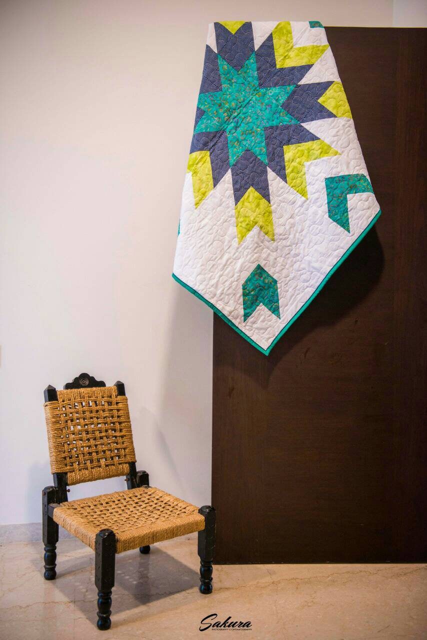 Star baby quilt styled on door