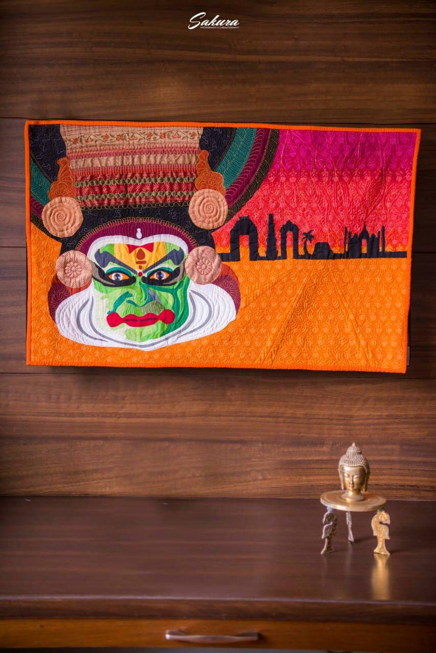 Quilt art hanging on wooden wall