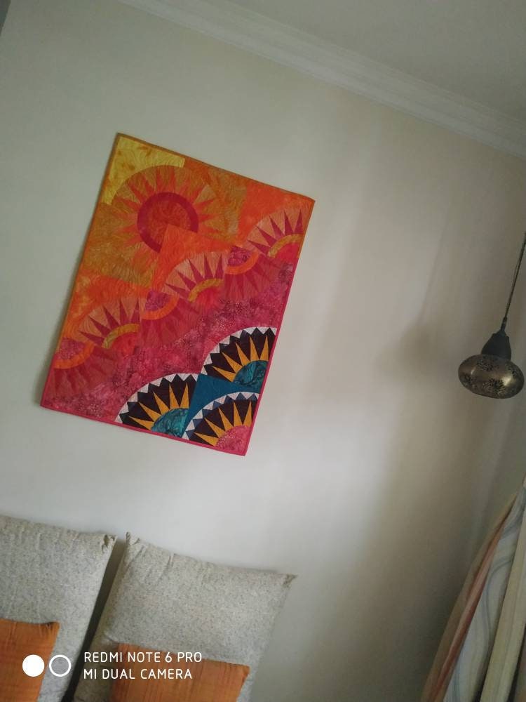 Orange ombré art quilt on wall