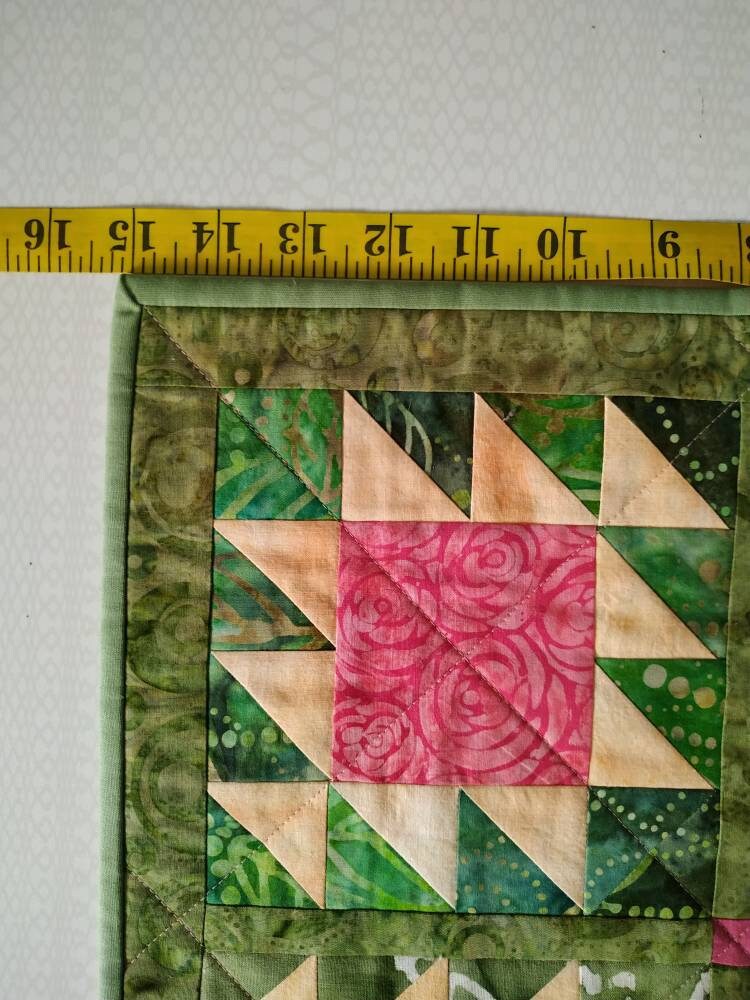 Close up of block on doll quilt and tape showing it’s dimensions