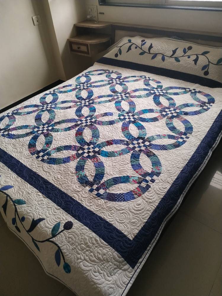 Blue and white double wedding ring quilt on queen bed