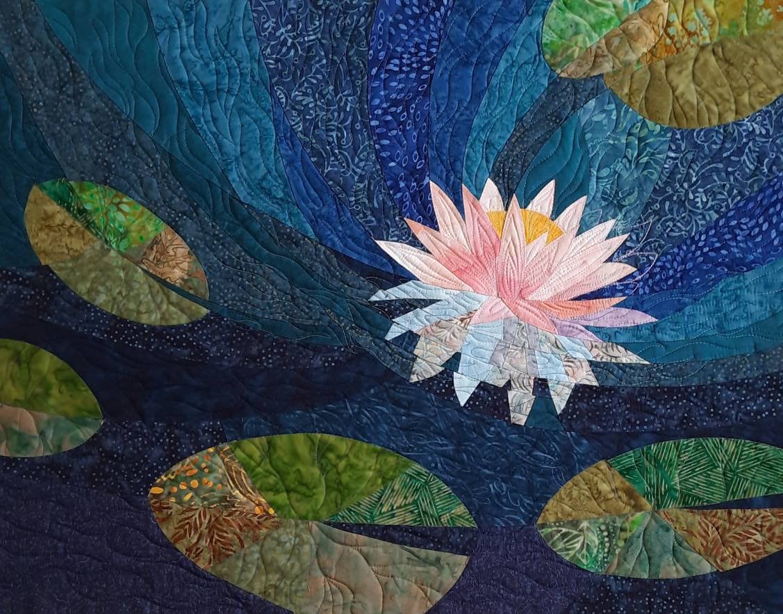 Main Image: Pink lotus quilted wall hanging in blue and green hues.