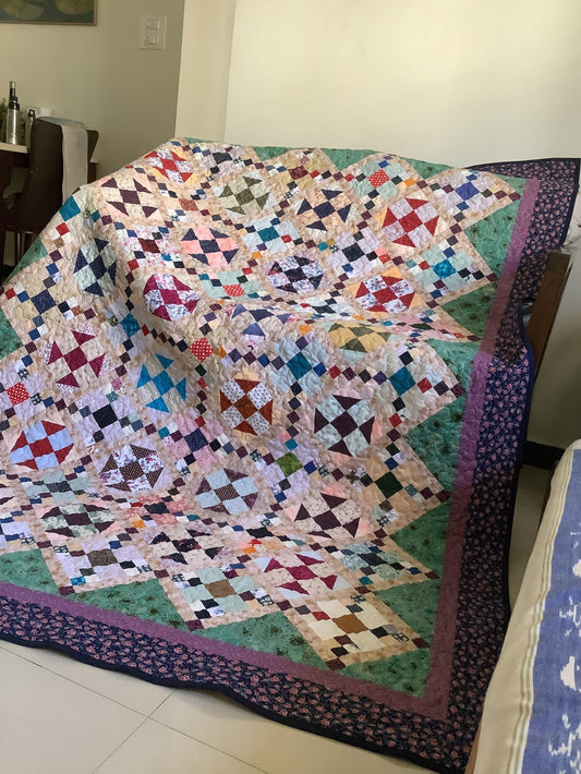 Handmade cozy queen size quilt styled on sofa