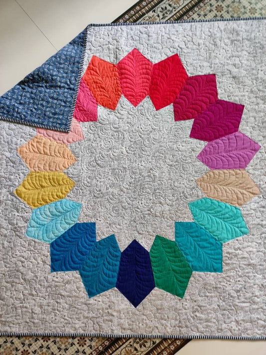 Rainbow quilt with folded corner to show backing fabric