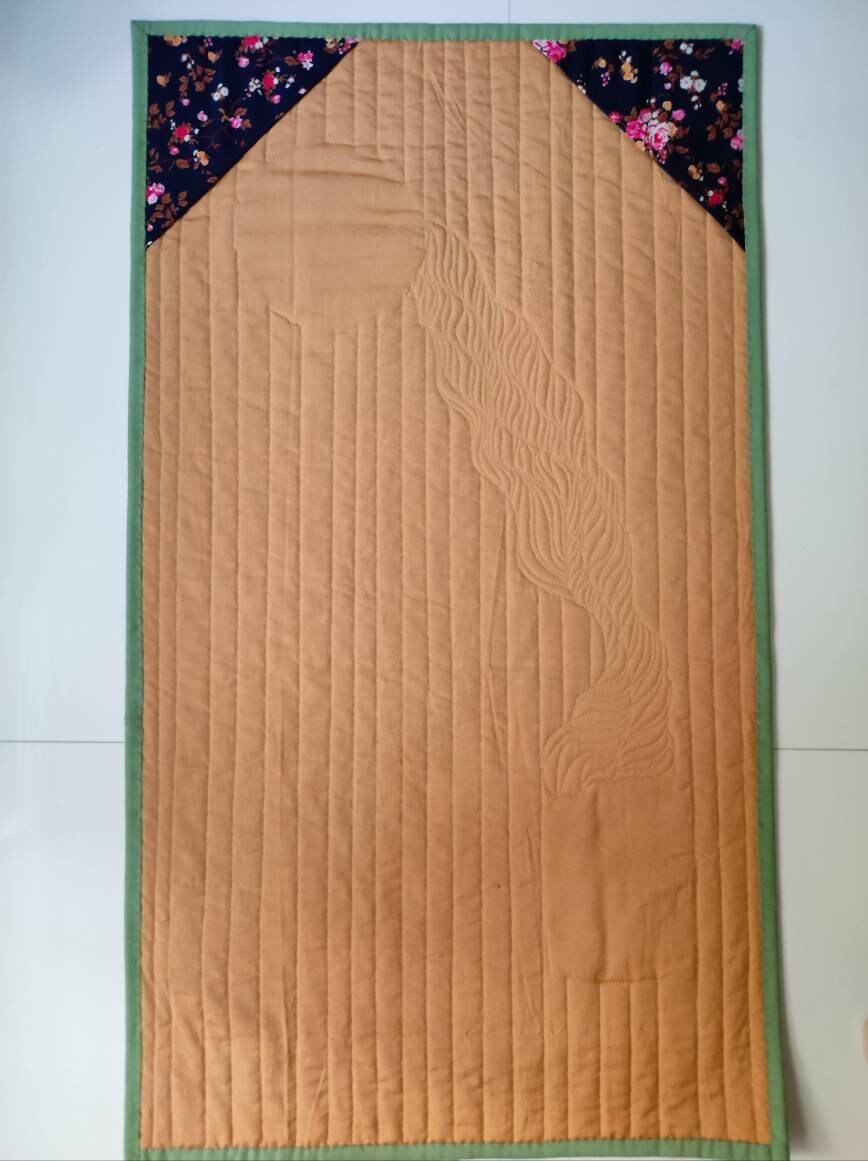 Backside of a quilt showing side corners for rod insert
