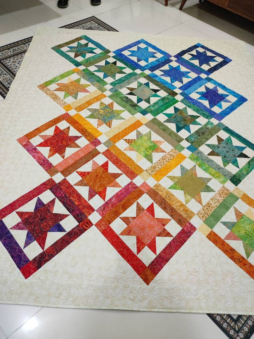 Twin size rainbow quilt on the floor