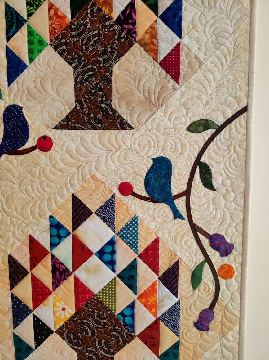 Details of appliqué and quilting on tree of life quilted wall hanging