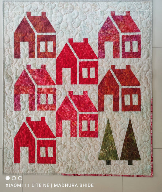 Front view of handmade Schoolhouse Block quilt in red and white.