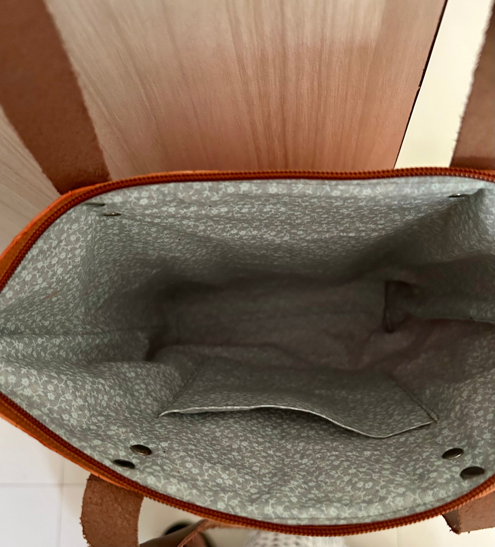 Top view of tote bag showing zipper closure And inside of the bag