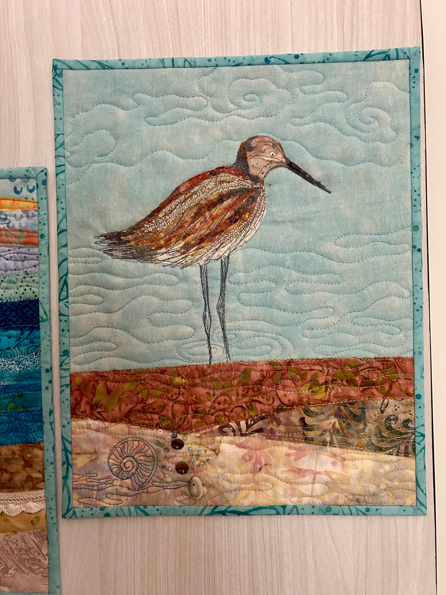 Beach bird fiber art quilt displayed on wall