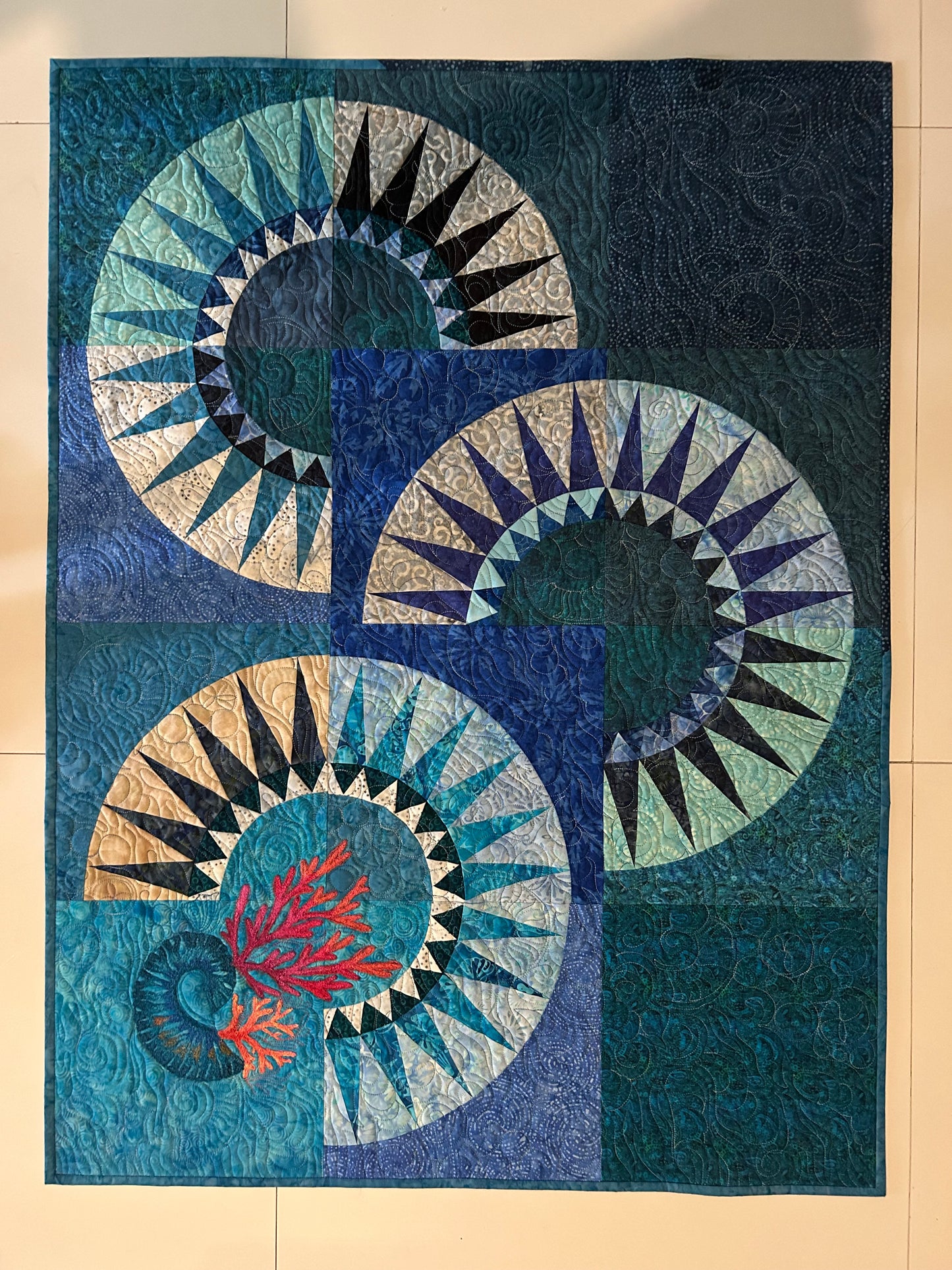 Handmade wall quilt in ocean blues and coral colors