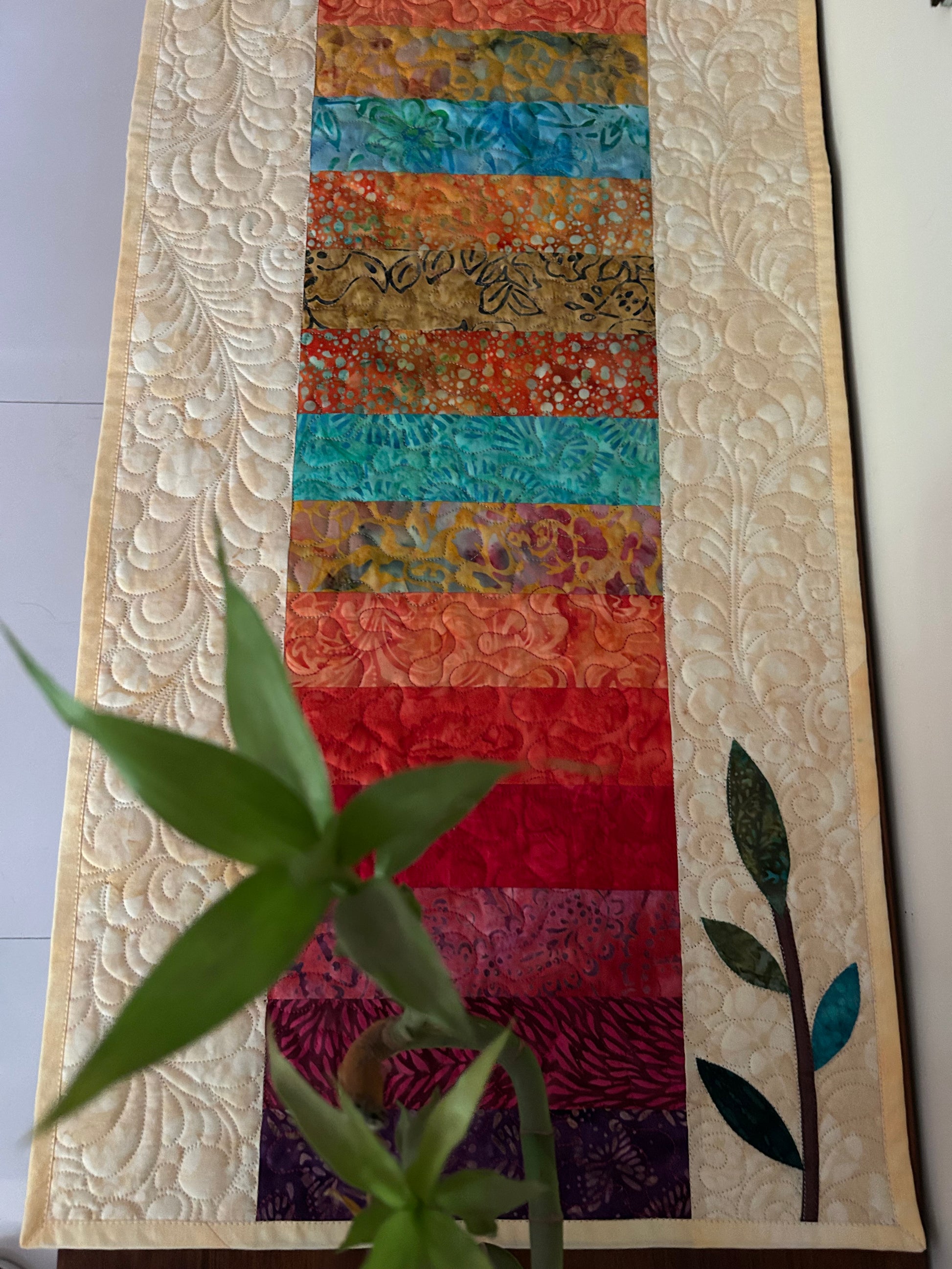 Appliquéd leafy branches on quilted table runner ends