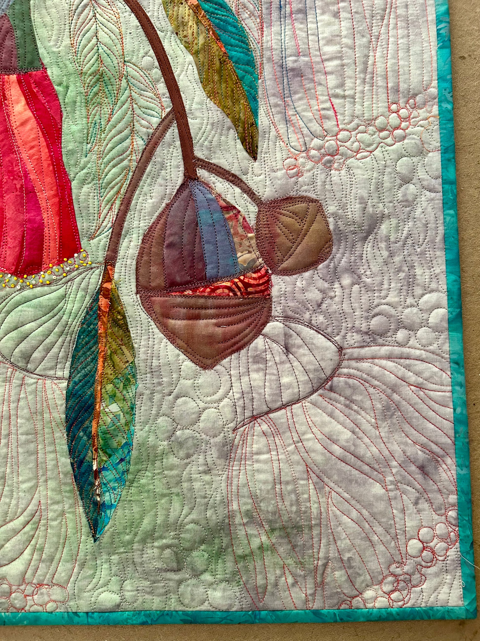 Details o appliqué and quilting stitches on green floral wall art