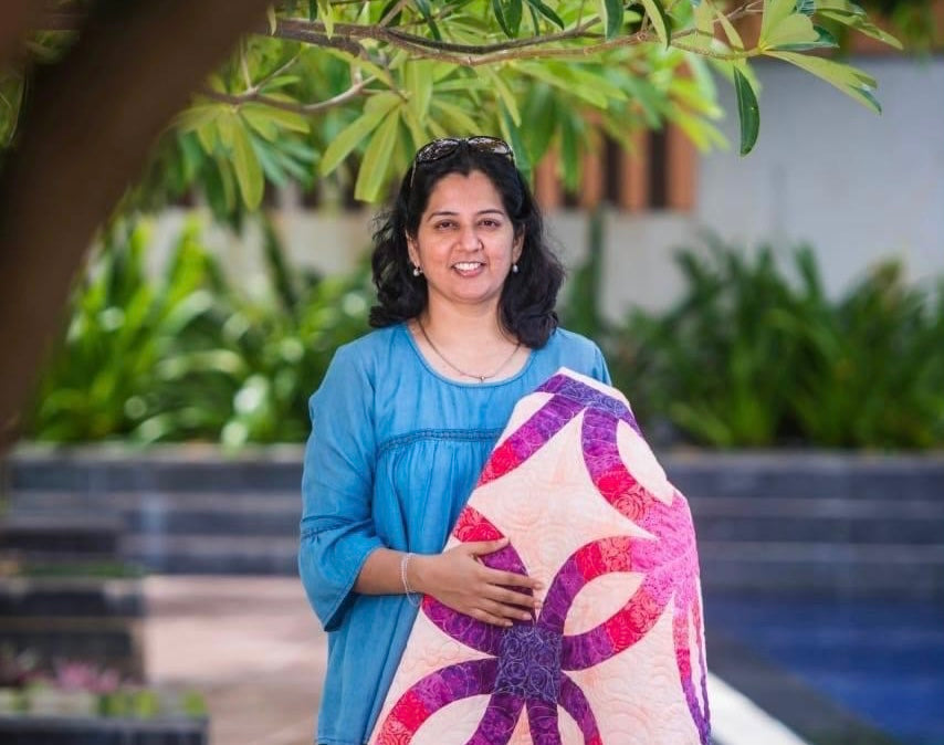 Quilter holding quilt in hands 