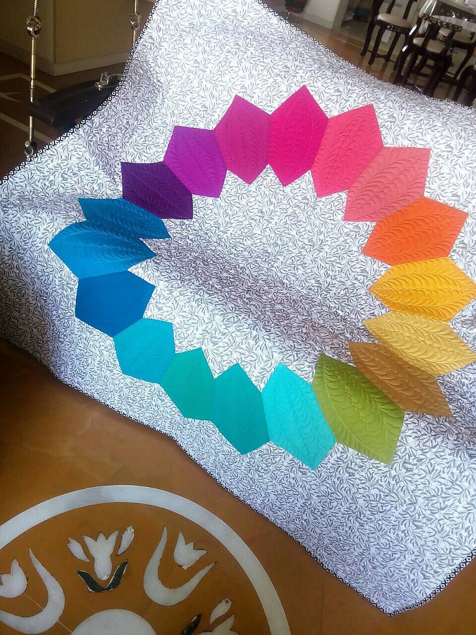 Colour wheel throw quilt tyled on swing 