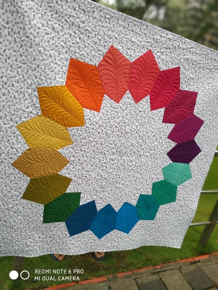Details of quilting on ombré rainbow quilted throw