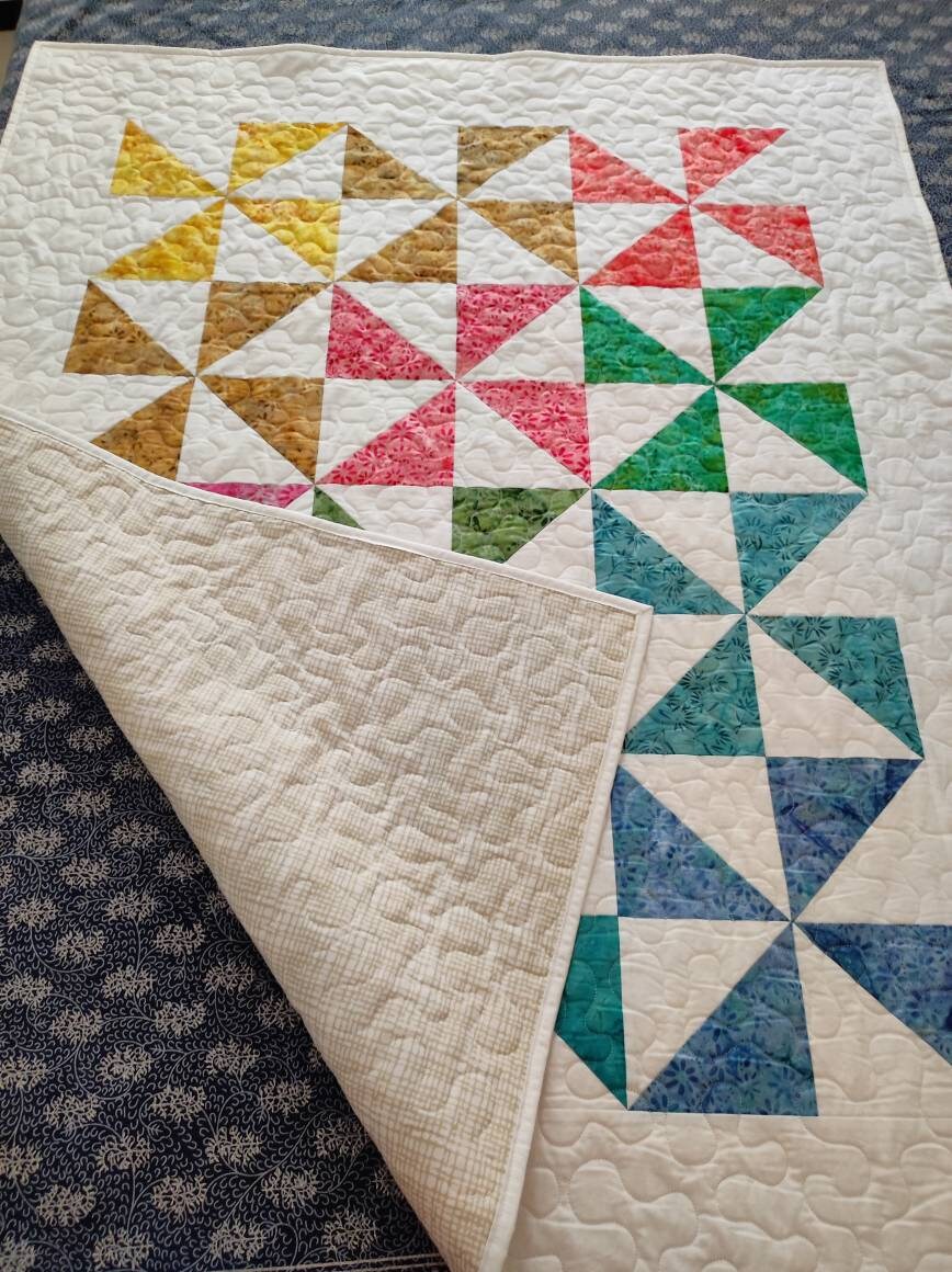 Beautiful pinwheel baby quilt showing backing fabric 