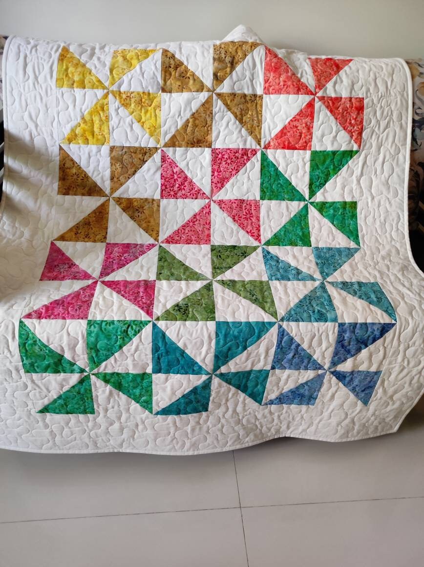 Pinwheel block baby quilt on sofa